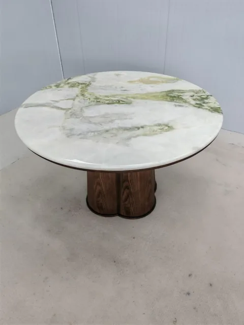 white stone coffee table, with a round top and bold veining, against a pale background