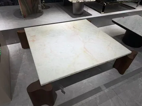 white stone dining table, with fine veining and a reflective finish, in a showroom