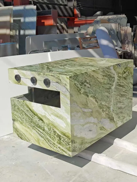 green stone vanity, with bold veining and a reflective finish, in a workshop