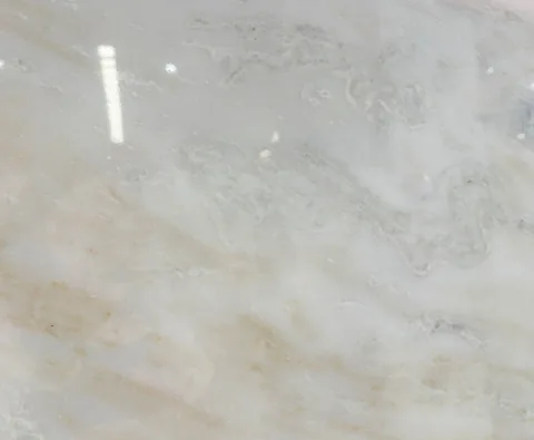 cream-beige stone slab, with cloudy mottling and a reflective finish, in a close surface view