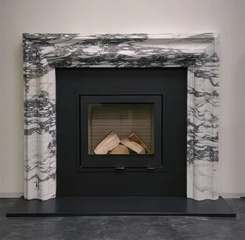 Arabescato Corchia marble fireplace surround, with bold veining, in a furnished room