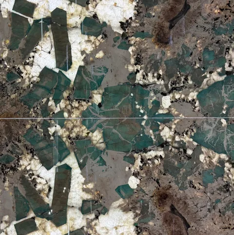 green stone slab, with a bookmatched slab pair and angular breccia fragments, in a close surface view
