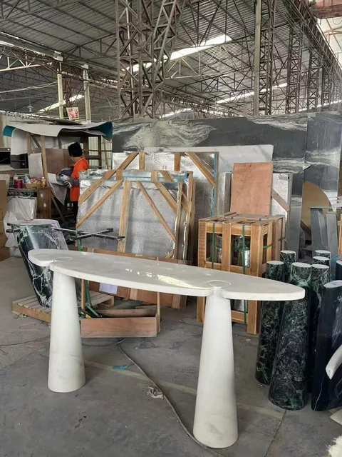 white stone dining table, with fine veining, shown from an angled view with single main form