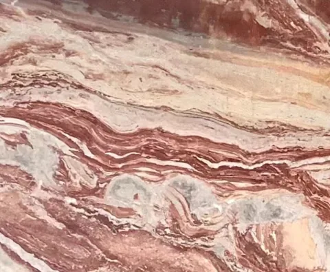 rose-red stone slab, with banded onyx-like striping, in a close surface view