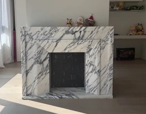 Arabescato Corchia marble fireplace surround, with bold veining, showing a single main form with broad sweeping markings