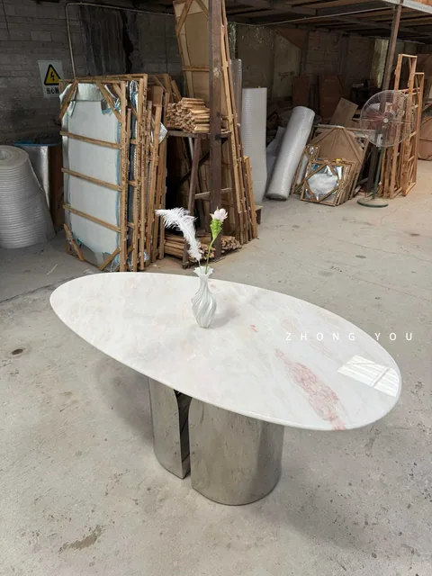 white stone dining table, with bold veining and a reflective finish, in a workshop
