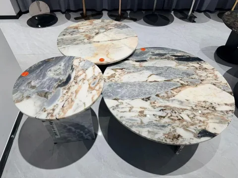 white stone coffee table, with a round top and bold veining, in a showroom