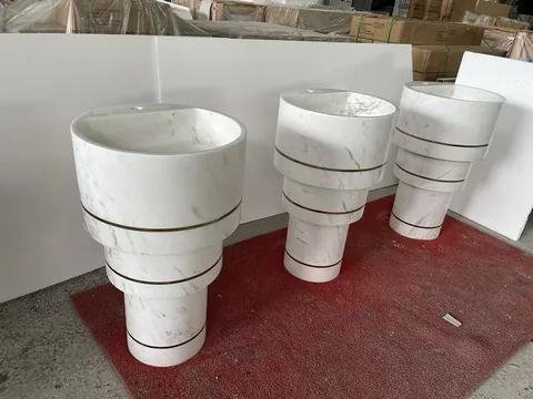 white stone sink, with a stone pedestal and fine veining, in a workshop