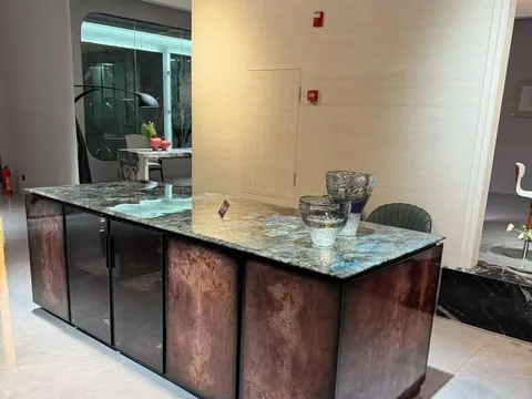 green stone countertop, with a single-level island and cloudy mottling, in a showroom