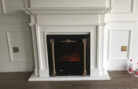 travertine fireplace surround, with stepped tiers and a plain surface, in a furnished room