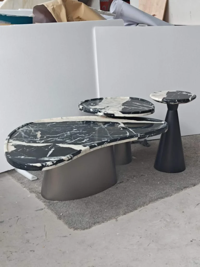black stone coffee table, with bold veining and a reflective finish, in a workshop