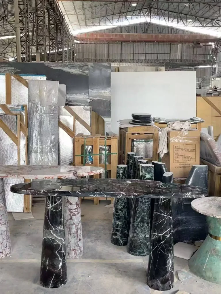 black stone dining table, with bold veining and a reflective finish, in a workshop