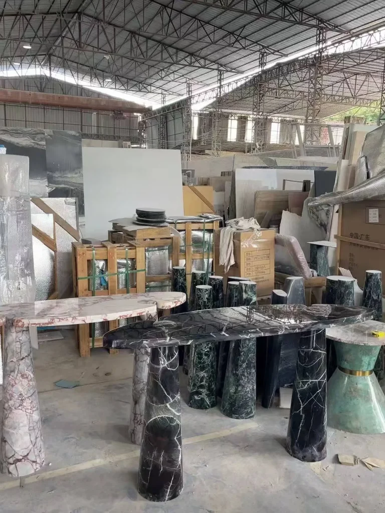 black stone dining table, with twin supporting bases and bold veining, in a workshop