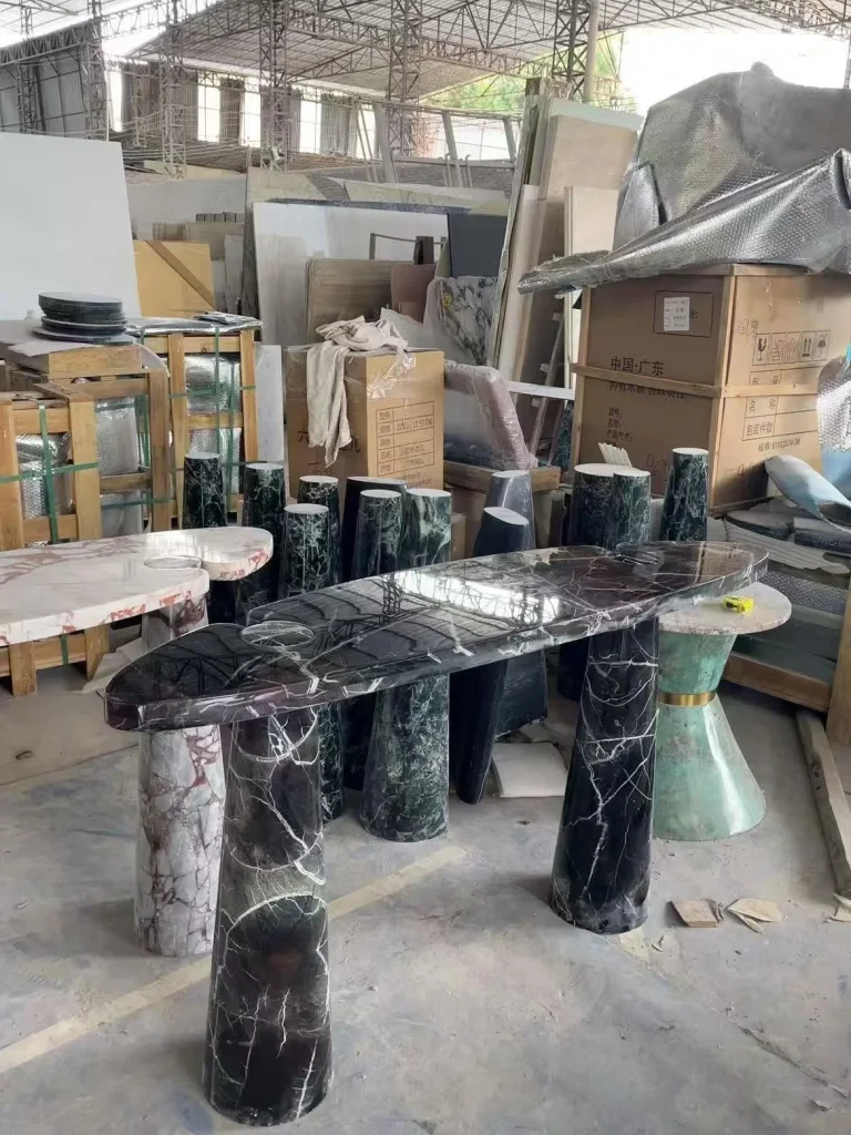 black stone dining table, with twin supporting bases and bold veining, in a workshop