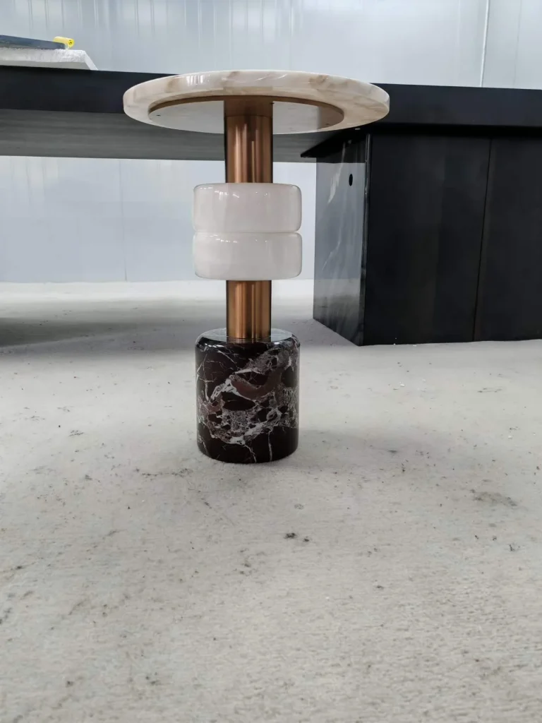black stone side table, with a central pedestal base and bold veining