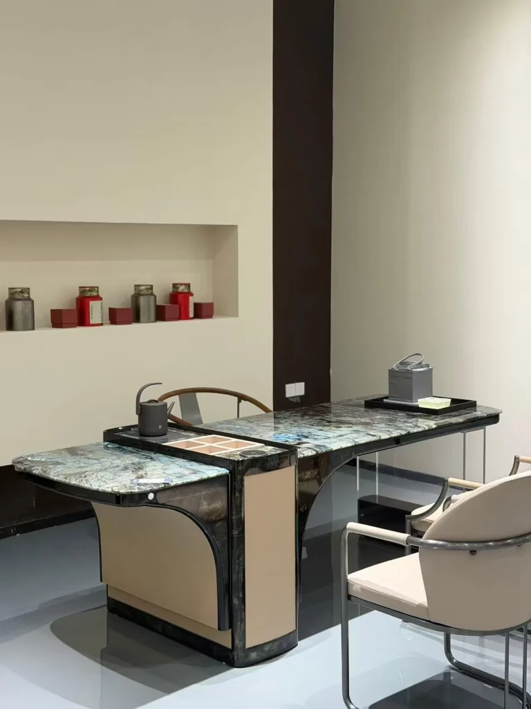 black stone desk, with cloudy mottling and a reflective finish, against a pale background