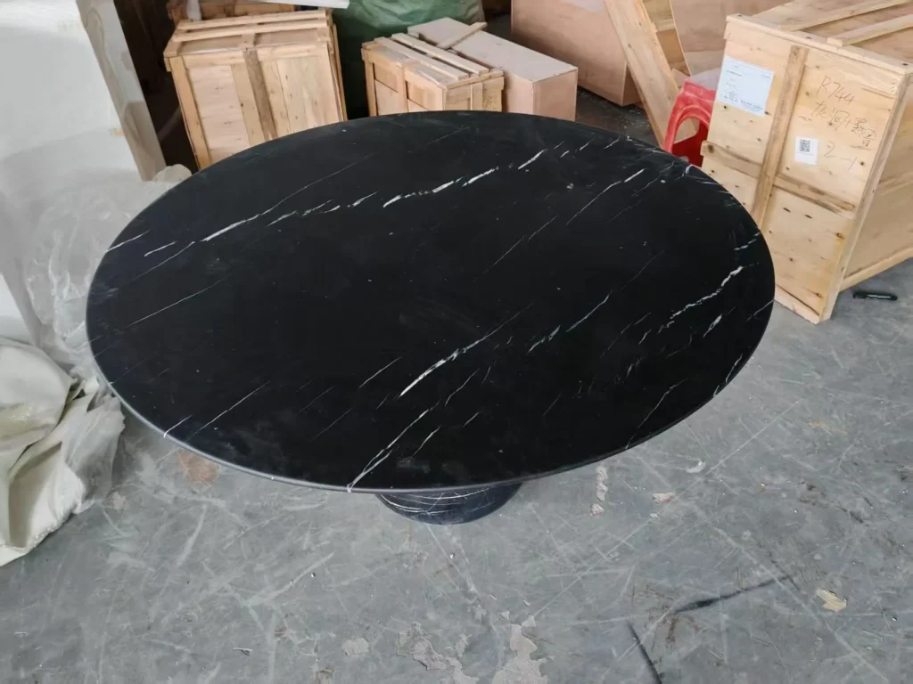 black stone dining table, with fine veining and a reflective finish, in a workshop