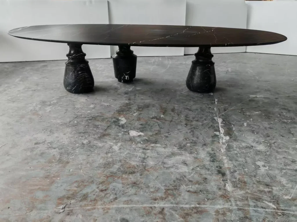 black stone dining table, with an oval top and fine veining, in a workshop