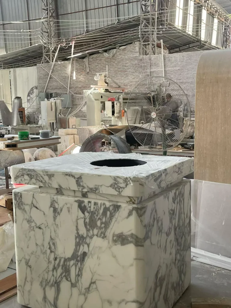 cream-beige stone vanity, with an integrated basin and bold veining, in a workshop