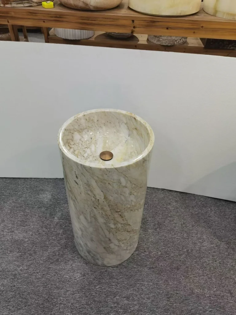 cream-beige stone sink, with fine veining and a reflective finish, in a showroom
