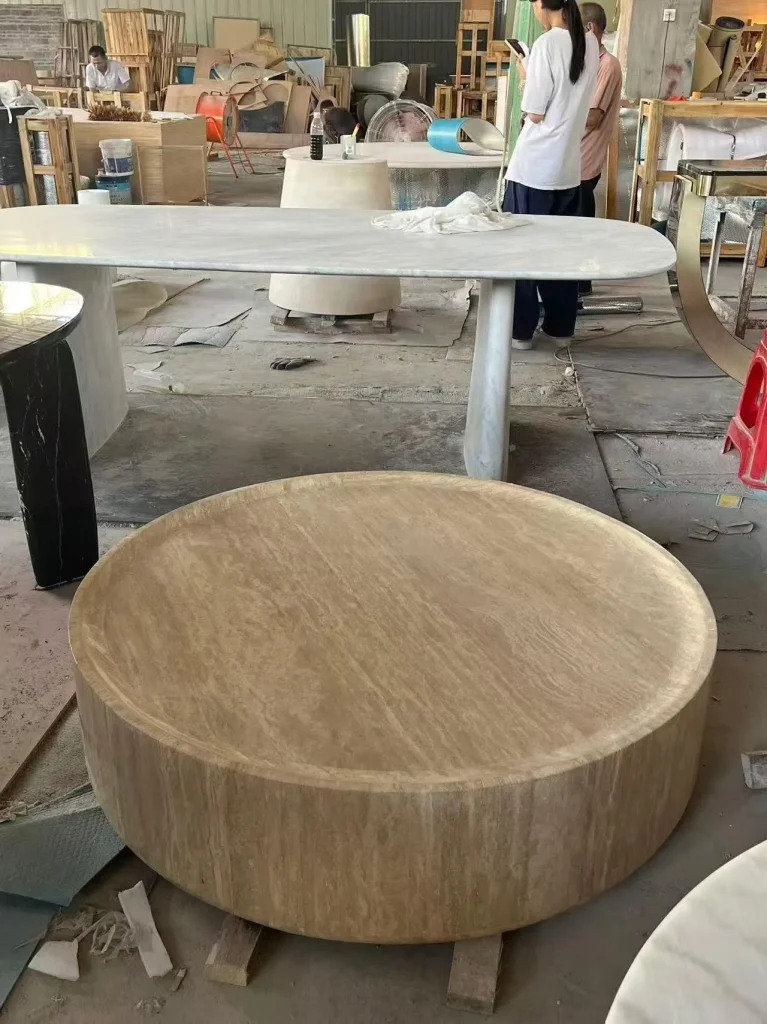 cream-beige stone coffee table, with linear travertine grain, in a workshop