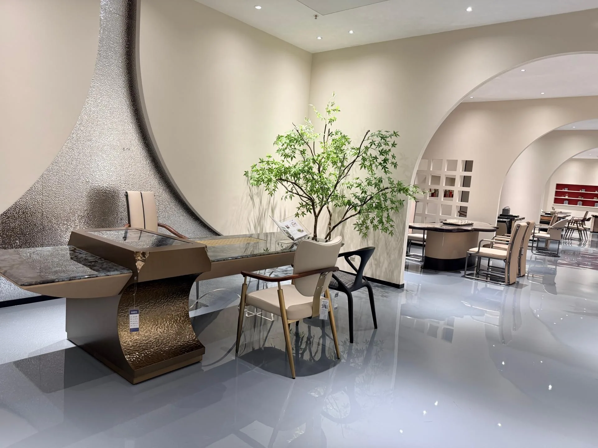 cream-beige stone desk, with a speckled texture and a reflective finish, in a showroom