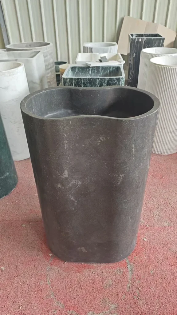 gray stone landscape feature, with a stone planter and a plain surface, in a workshop