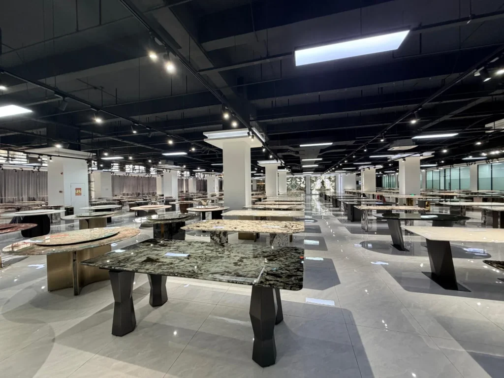 green stone dining table, with a rectangular top and cloudy mottling, in a showroom