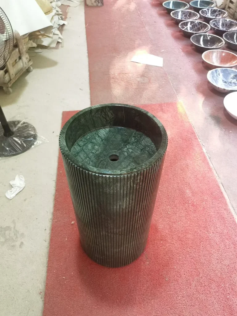 green stone sink, with fine veining and a reflective finish, in a workshop