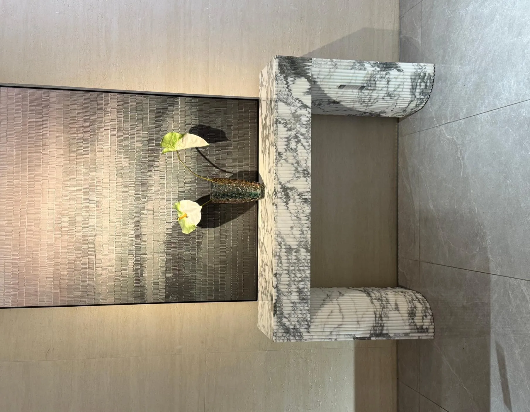 white stone console table, with twin supporting bases and bold veining, in a furnished room