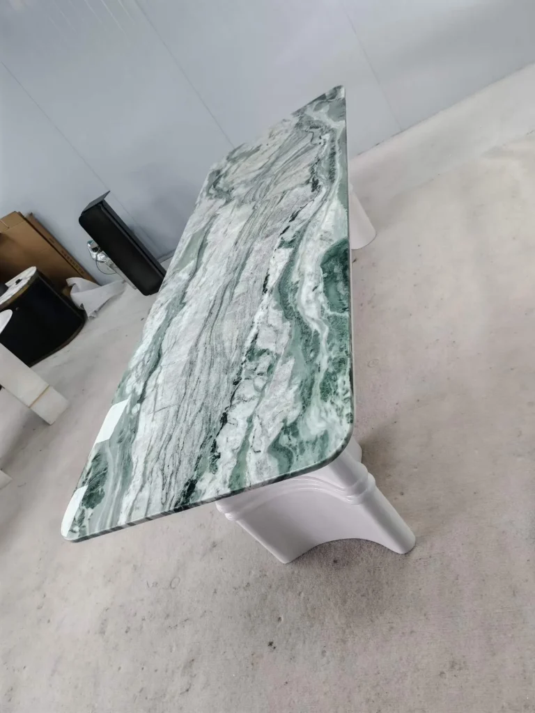 white stone dining table, with bold veining and a reflective finish, in a workshop