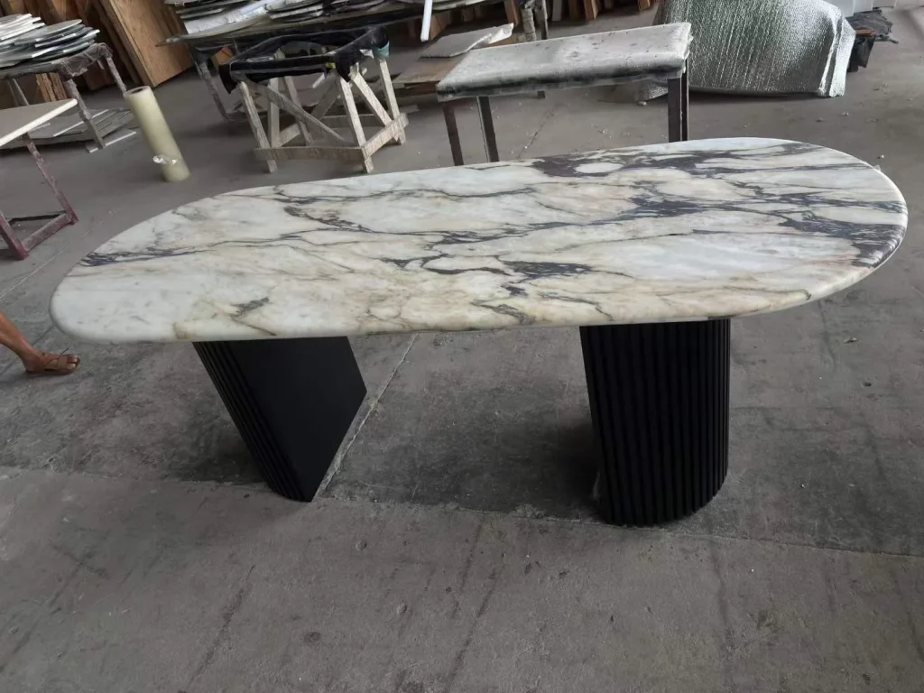 white stone dining table, with bold veining, shown from an angled view with broad sweeping markings