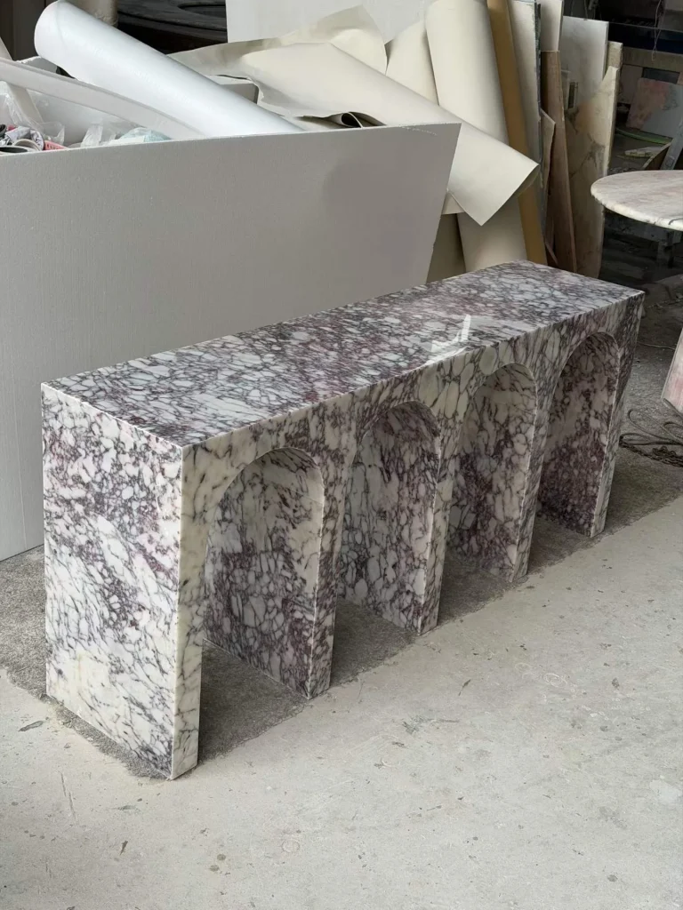 white stone bench, with a plinth-like bench and bold veining, in a workshop