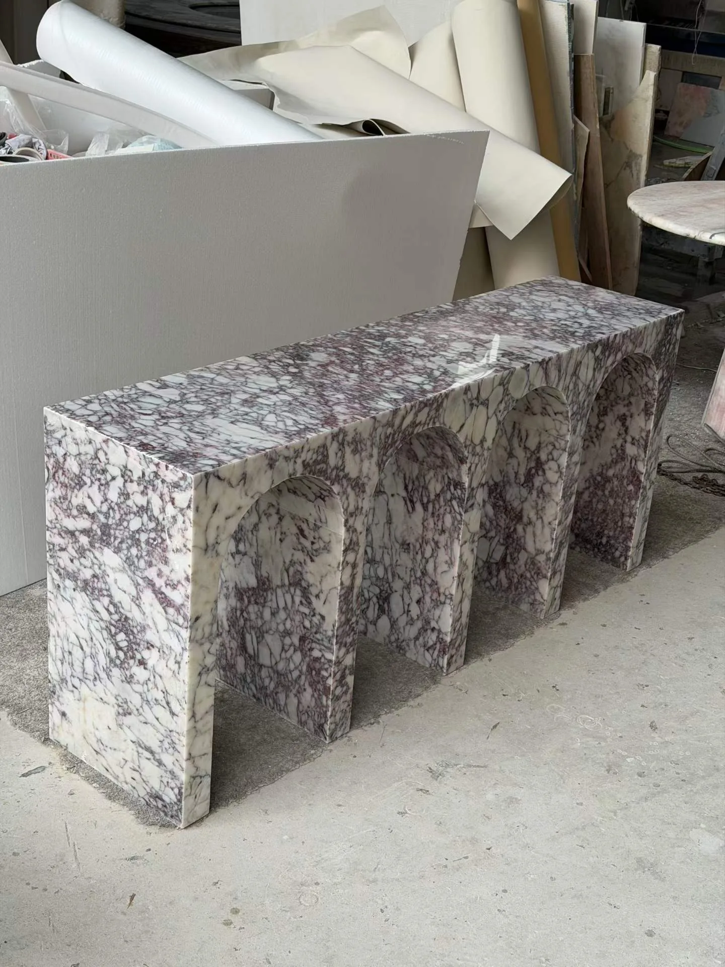 white stone bench, with a plinth-like bench and bold veining, in a workshop
