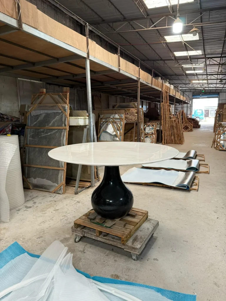 white stone dining table, with fine veining and a reflective finish, in a workshop