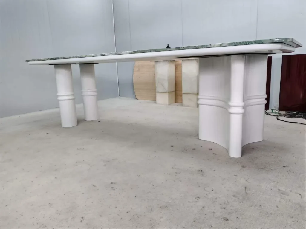 white stone dining table, with fine veining and a reflective finish, in a workshop