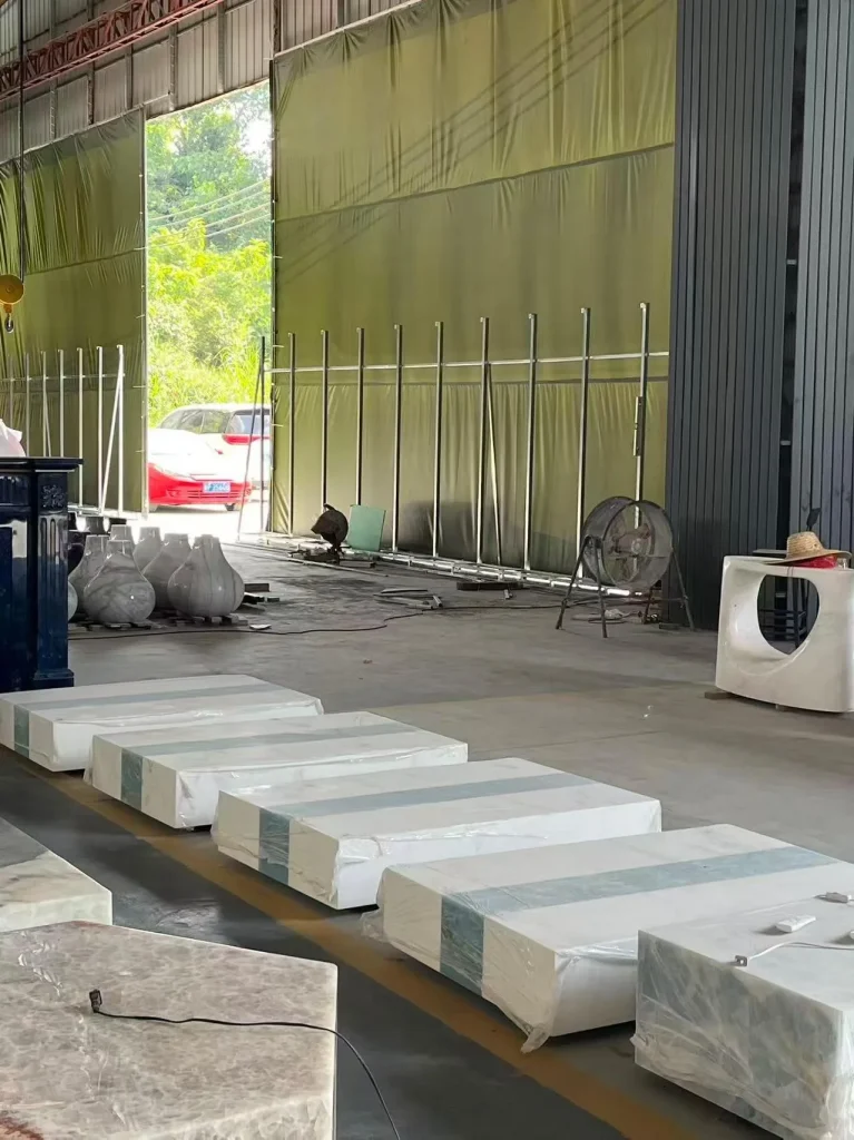 white stone slab, with a stack of related slabs and fine veining, in a workshop